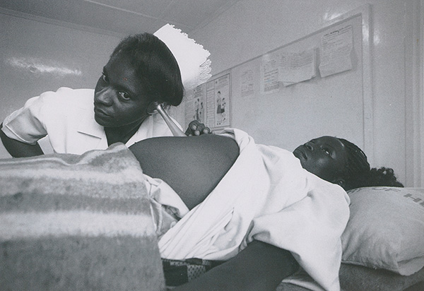 Photo of a nurse listening to a pregnant woman's baby