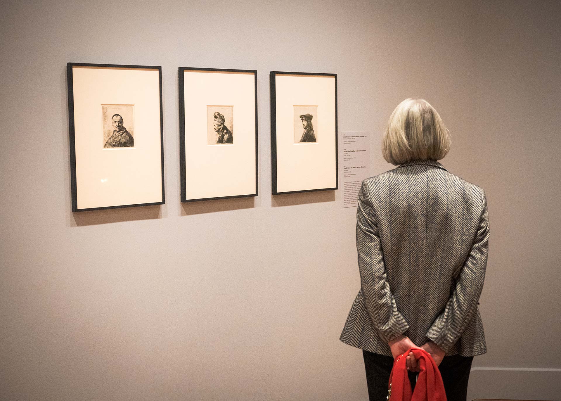 A guest viewing three works in the 'Rembrandt' exhibition