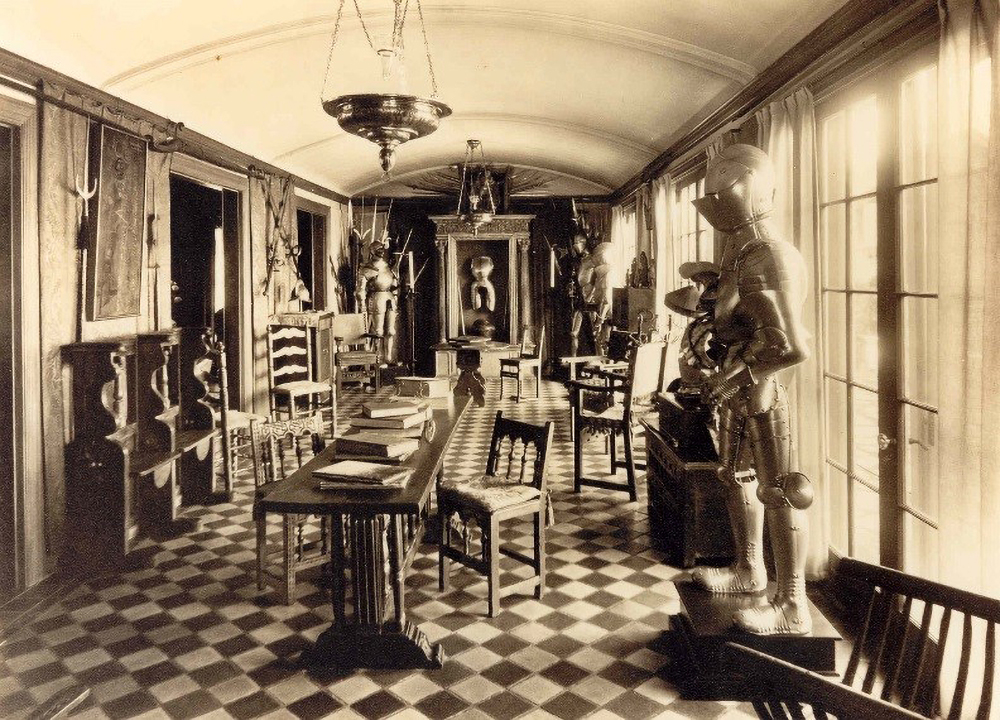 A room in Higgins' home with table, chairs and a variety of objects from his collection on display, including suits of armor and weapons