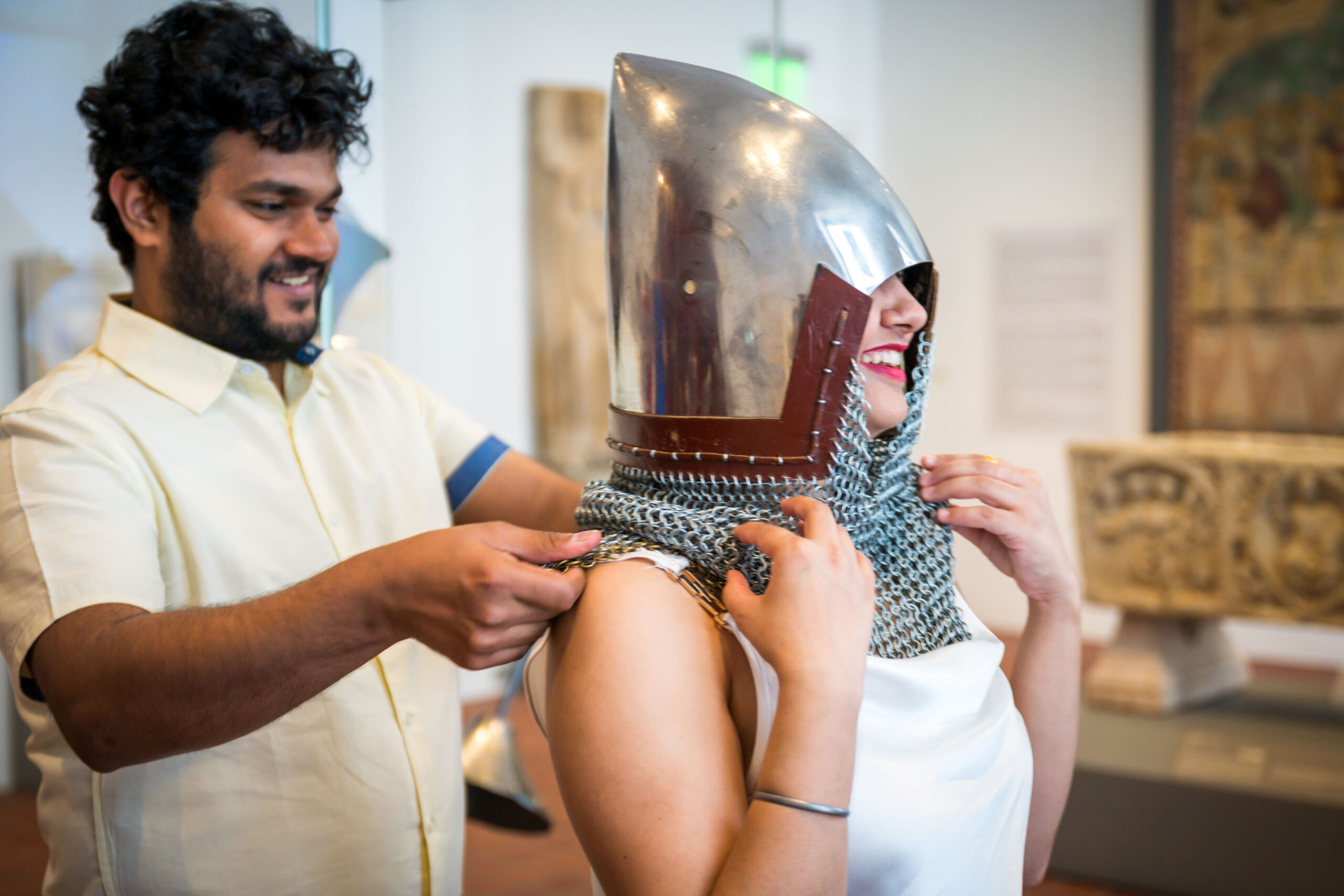 Two smiling guests trying on armor