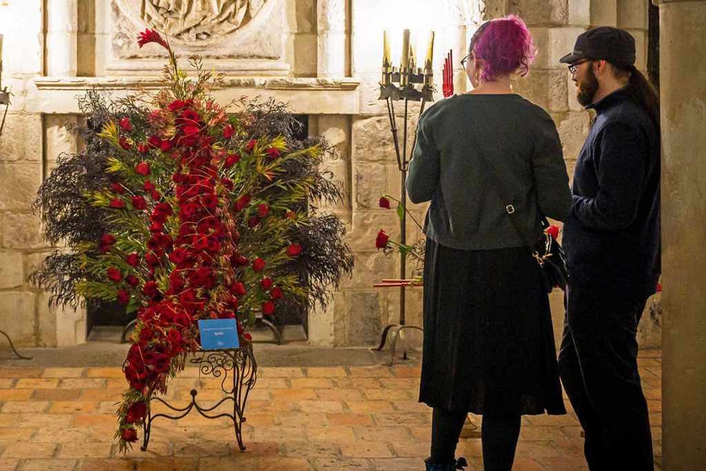 Two visitors viewing a floral display in WAM's Chapter House