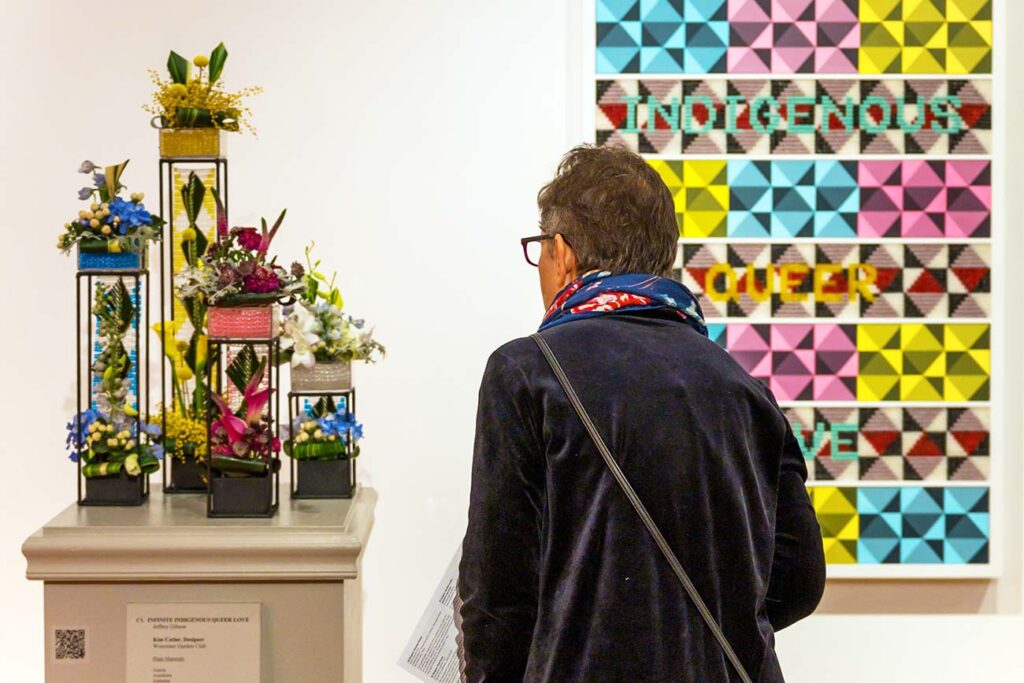 A visitor views a floral interpretation of a contemporary artwork