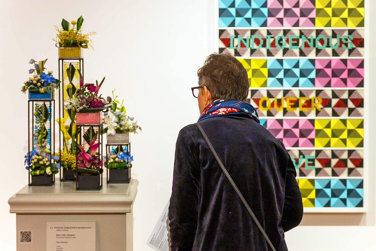 A visitor views a floral interpretation of a contemporary artwork