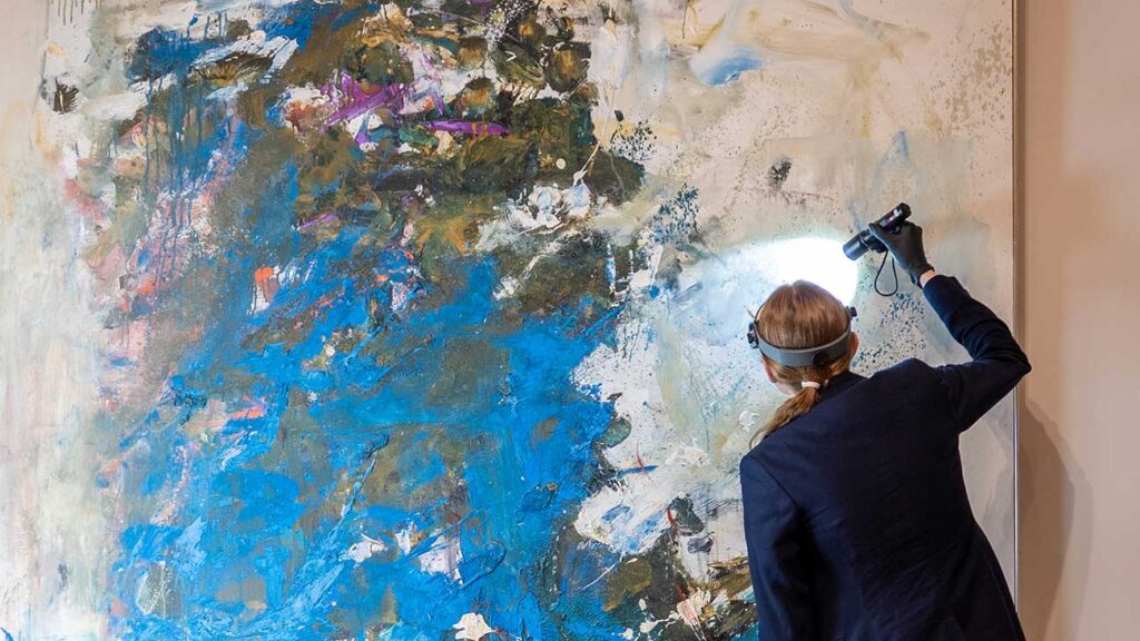 A conservator working on Joan Mitchell's painting 'Blue Tree'