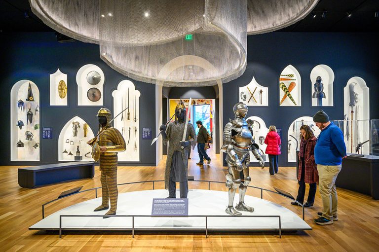 View of the front Arms and Armor gallery with three suits of armor on display in the center