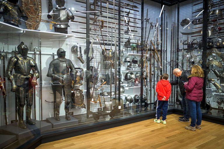 A small group of visitors viewing objects in open storage