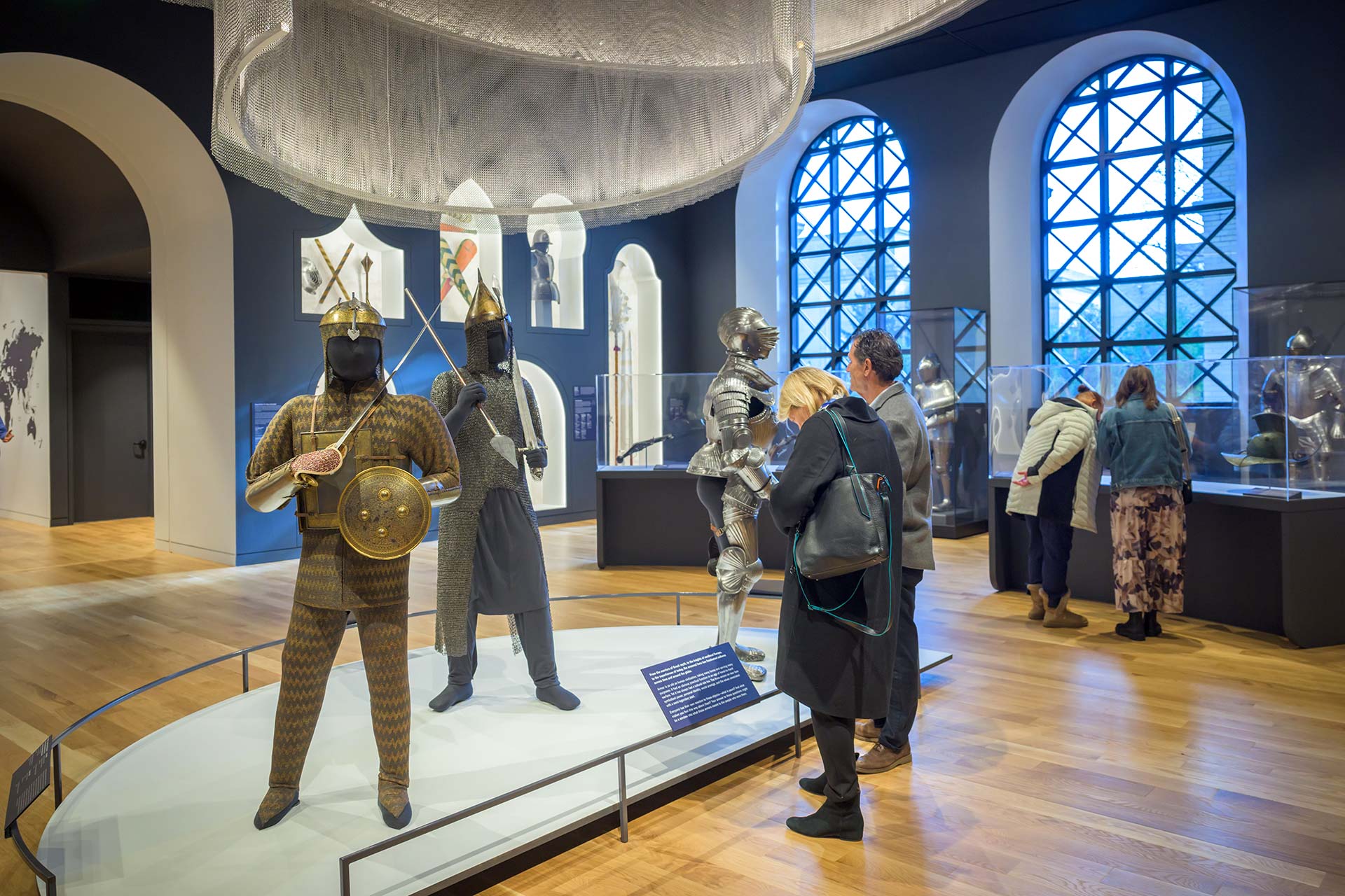 Visitors viewing suits of armor and other objects in the Arms and Armor Galleries