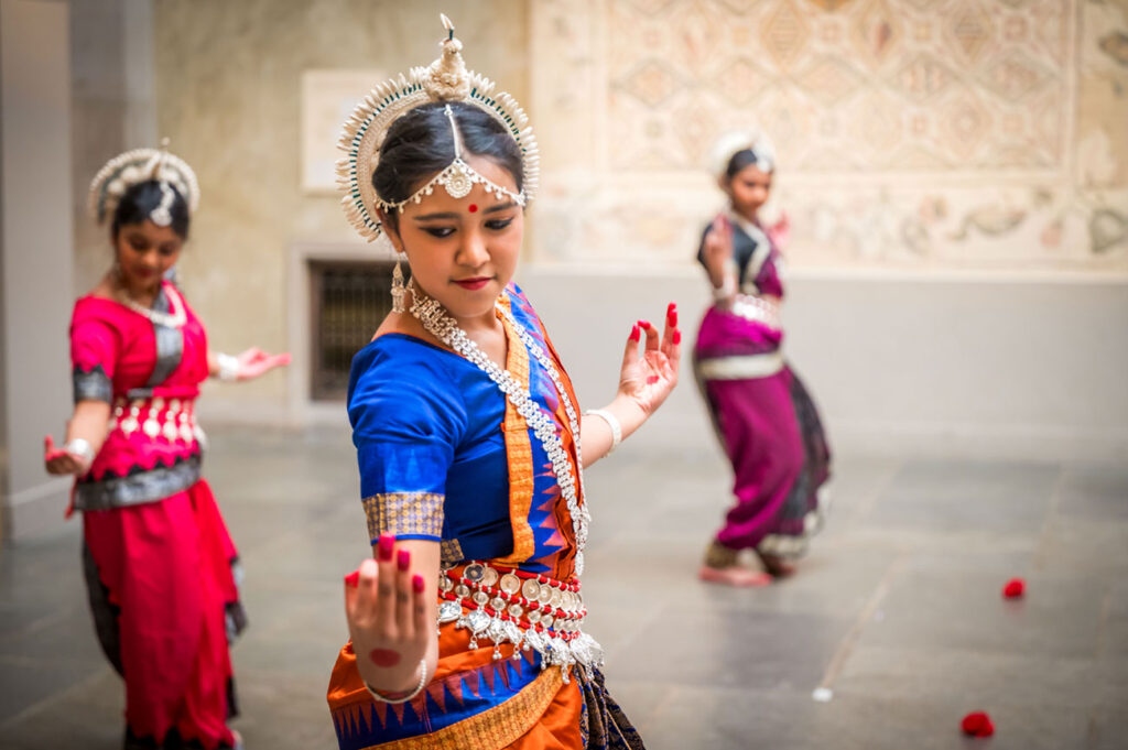 Three dancers perform in traditional Indian dress during a Diwali Celebration