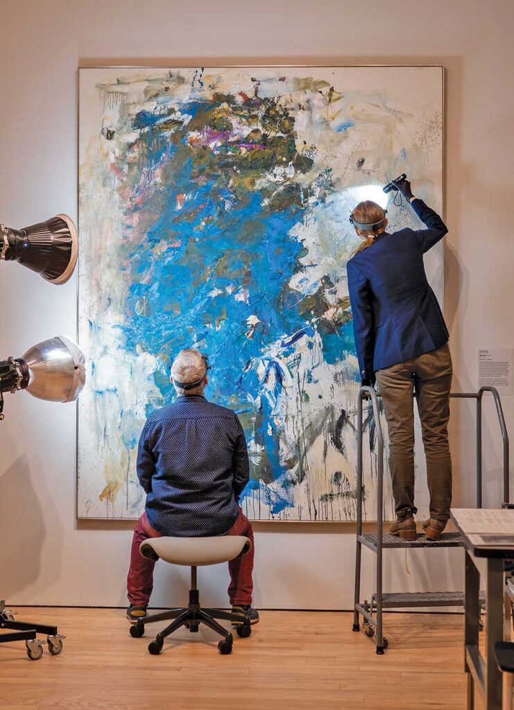 Paintings conservators examine the surface of Joan Mitchell's 'Blue Tree'.