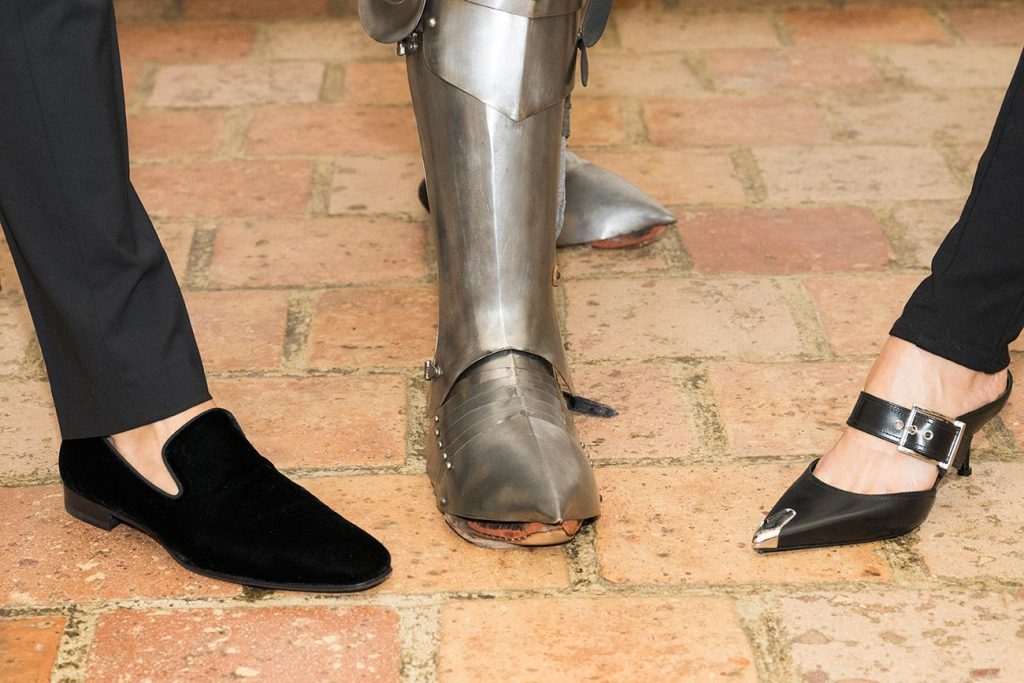 Party-goers show off their footwear - one wearing knight's armor