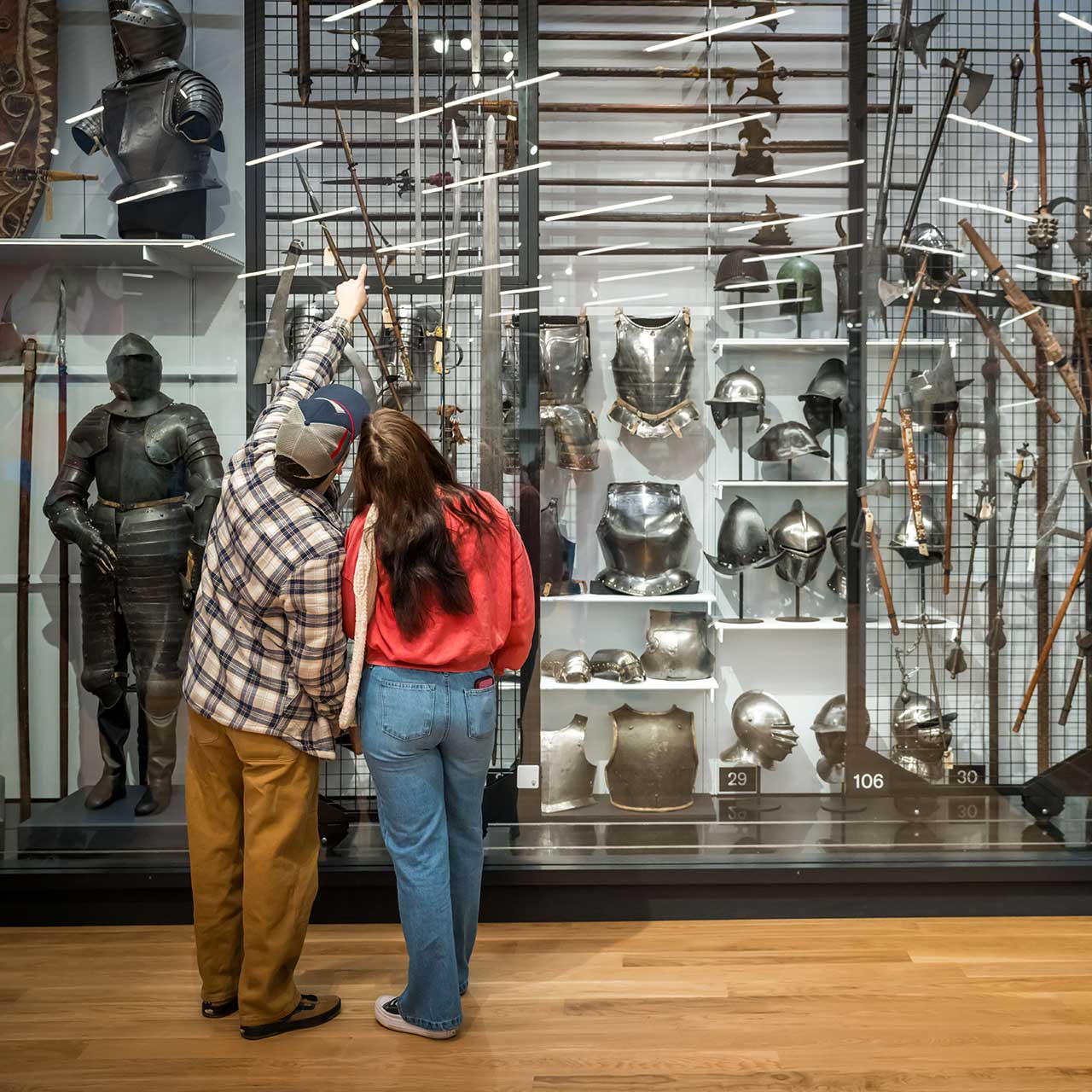 Two visitors together viewing Arms and Armor open storage