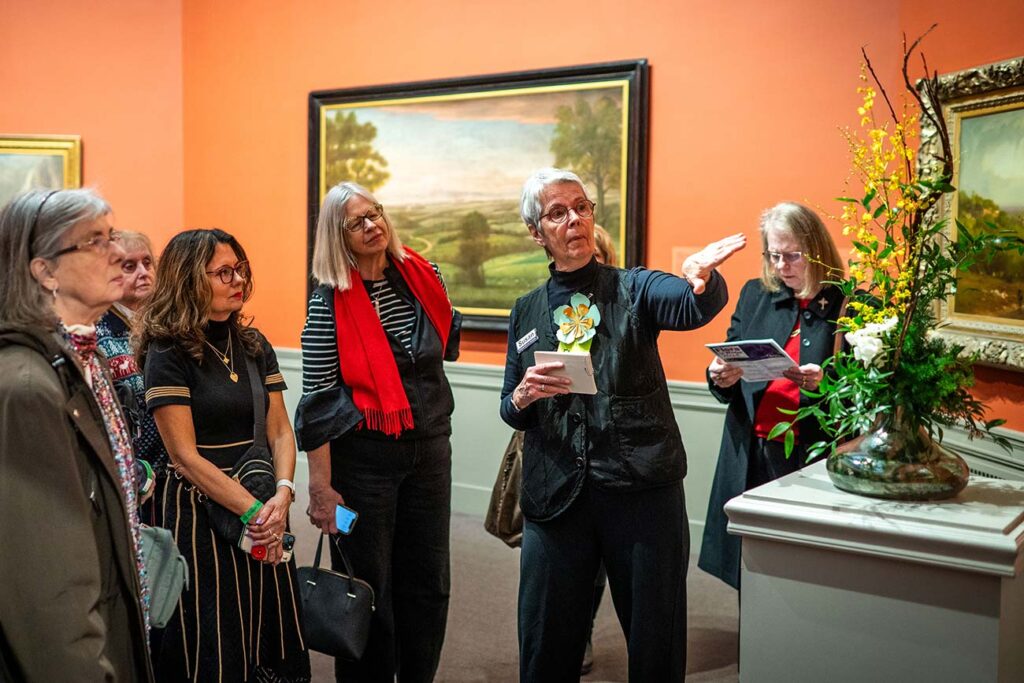 A guided tour group viewing an interpretive arrangement during Flora in WInter