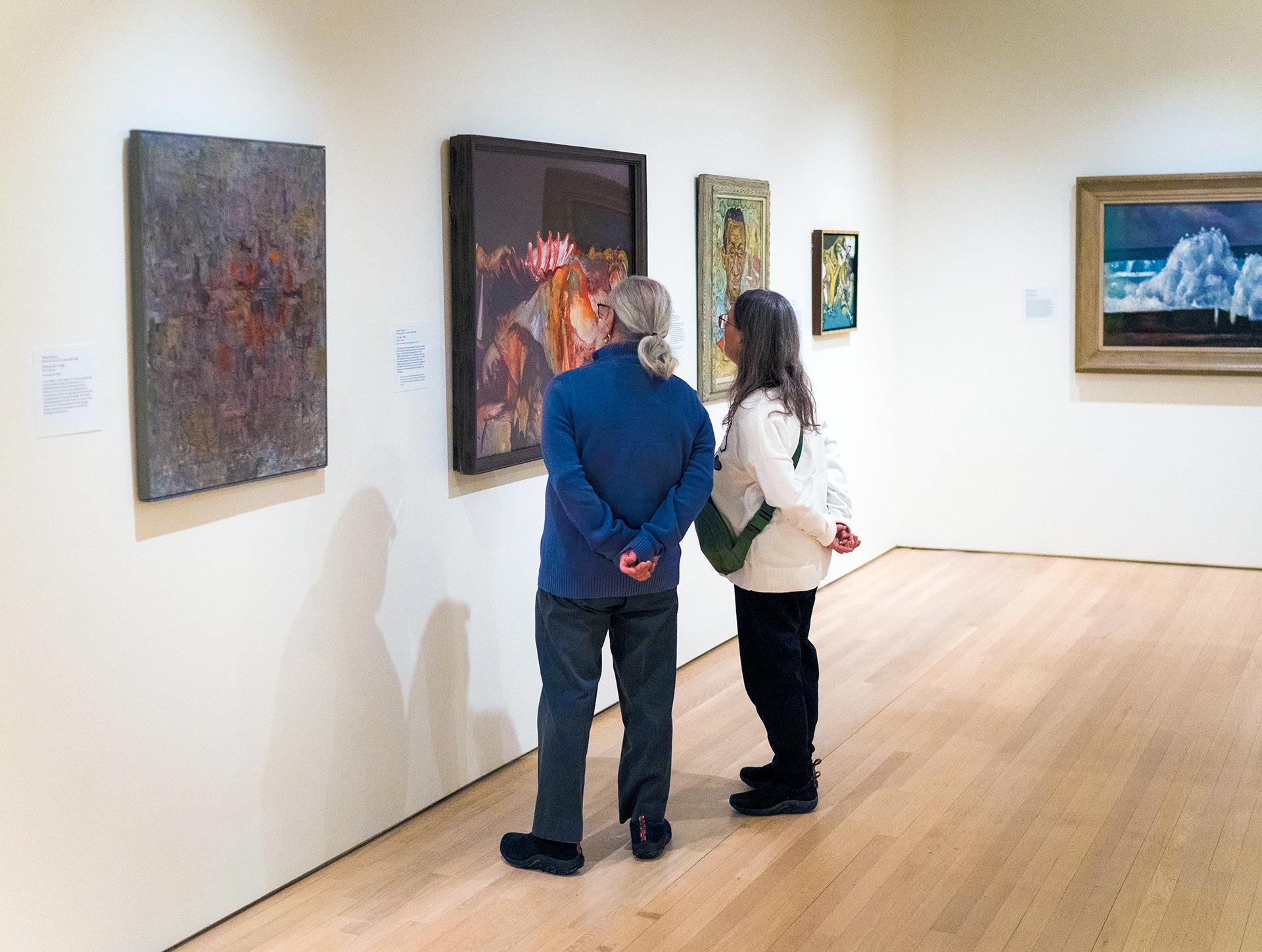 Two visitors standing together viewing artworks in the Modern Art gallery