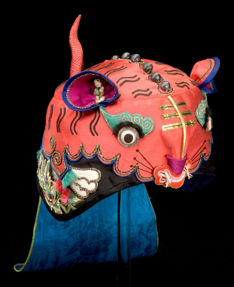 Protective Red Tiger Hat with Tail and a Hat Flap Decorated with Birds, Flowers and Auspicious Designs, about 1875, Qing Dynasty (1644-1911), satin, silk thread, gold foil, metal beads and paper