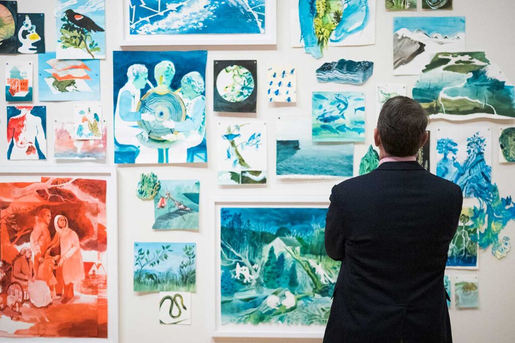 A visitor viewing works in the exhibition 'Fever Dreams of a Cool-Breathed Earth'