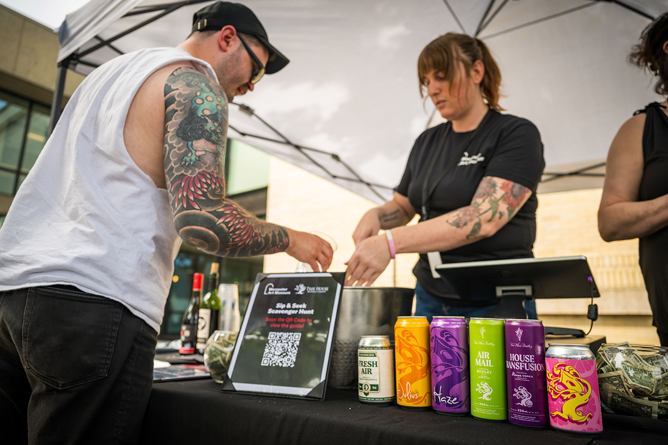A visitor purchasing a drink at a Tree House Brewery tent