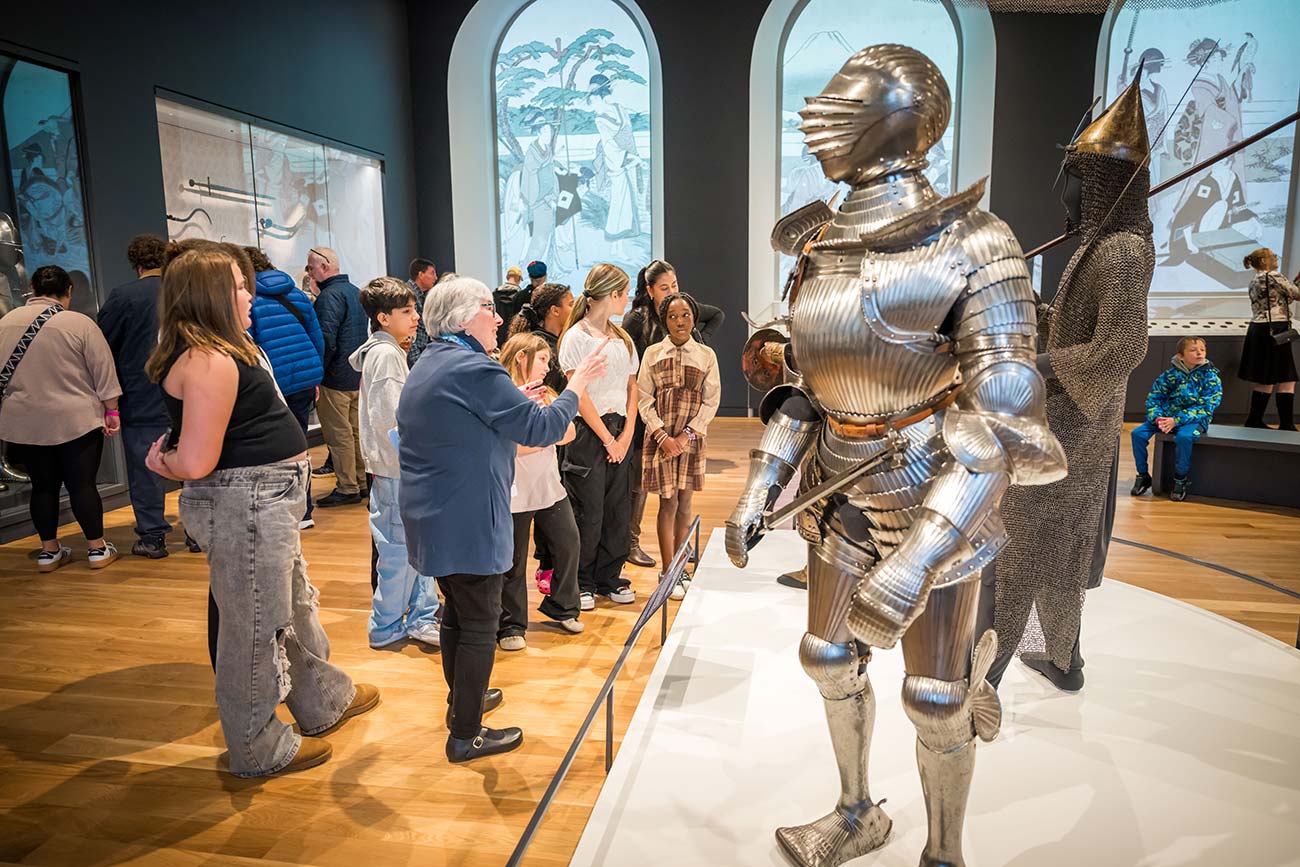 A tour group explores the Arms and Armor Galleries